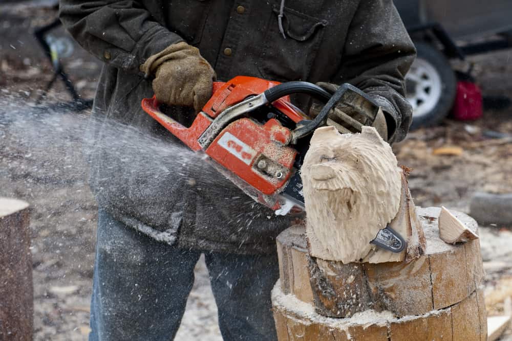 man carving a wooden bear with a chainsaw