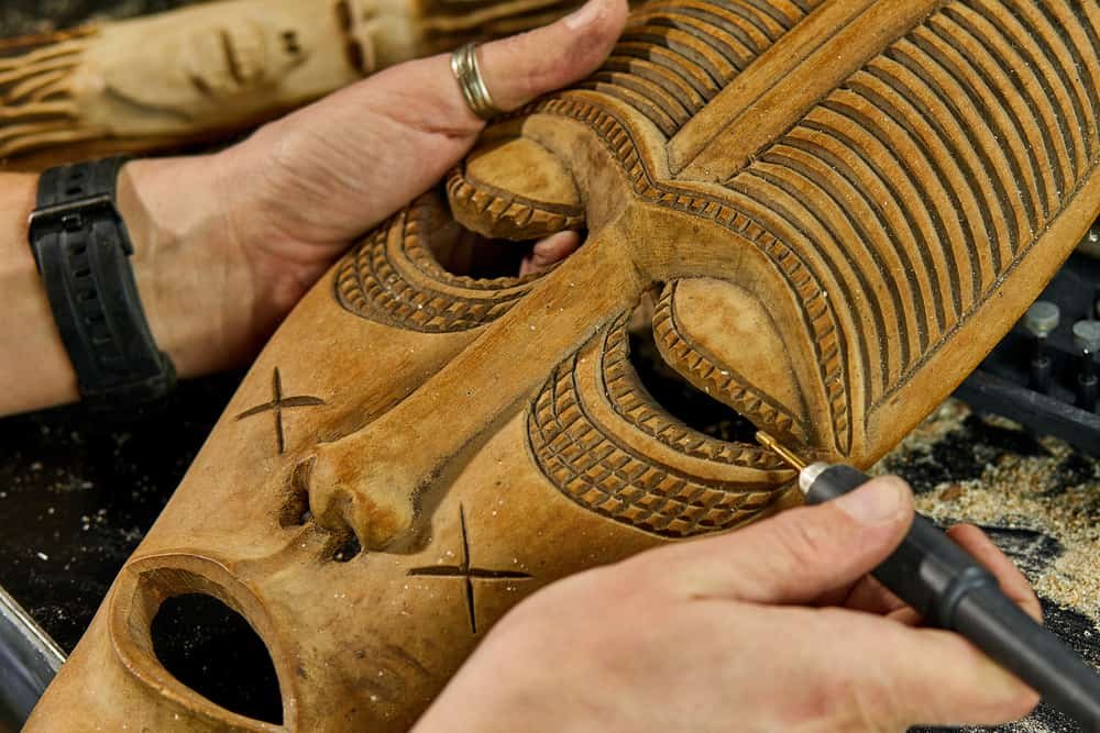 Close up male hands using power wood working tools graver, carving while crafting, Creating craft handmade souvenirs.