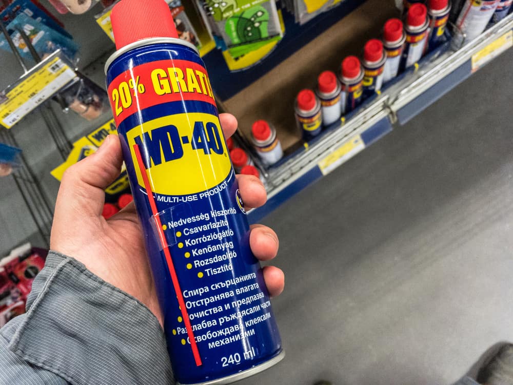 a man holding a can of wd-40 in his hand